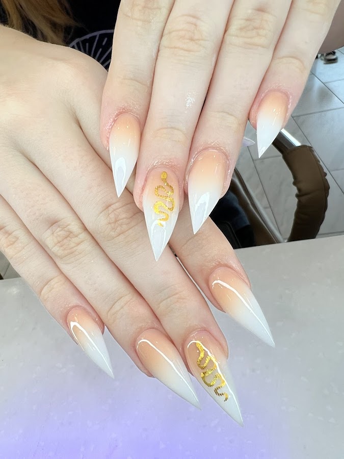 White and nude ombré stiletto nails with hand-painted gold snake art